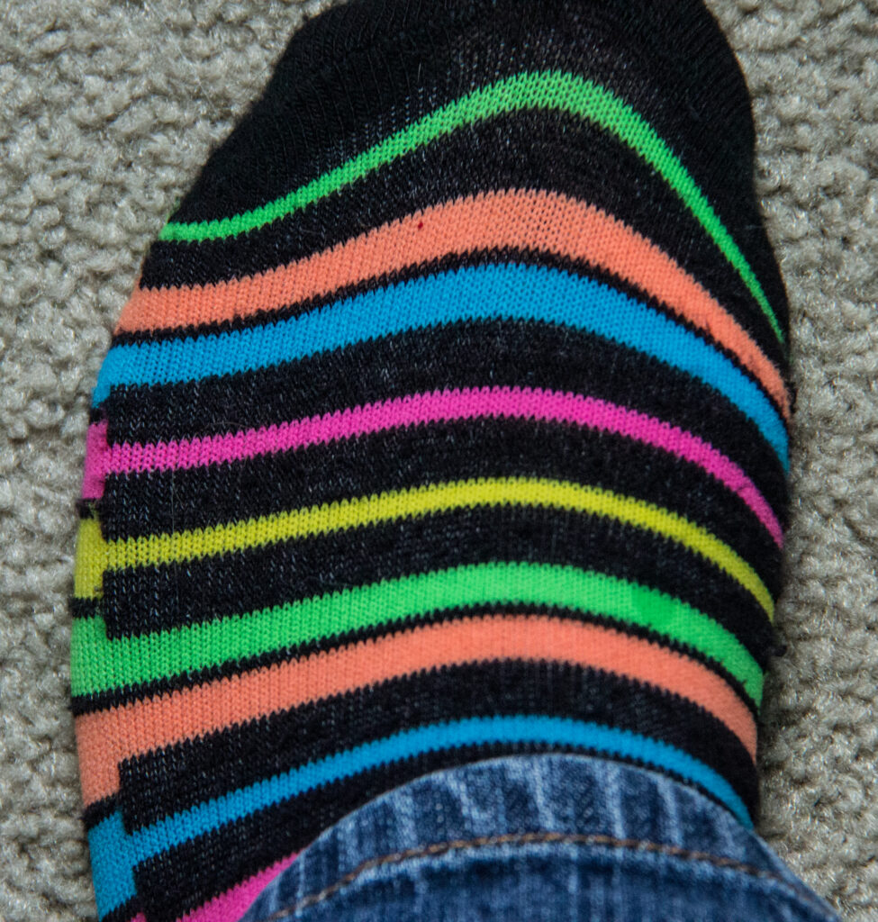 A close up picture of a sock with neon piano key design