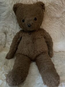 A photograph of a well loved brown teddy bear